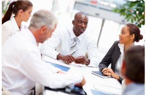 Five people at a desk discussing a project